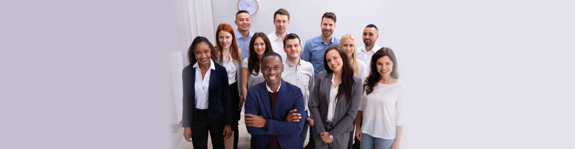 Group Of Young Successful Multi-ethnic Businesspeople Standing In Office Looking At Camera